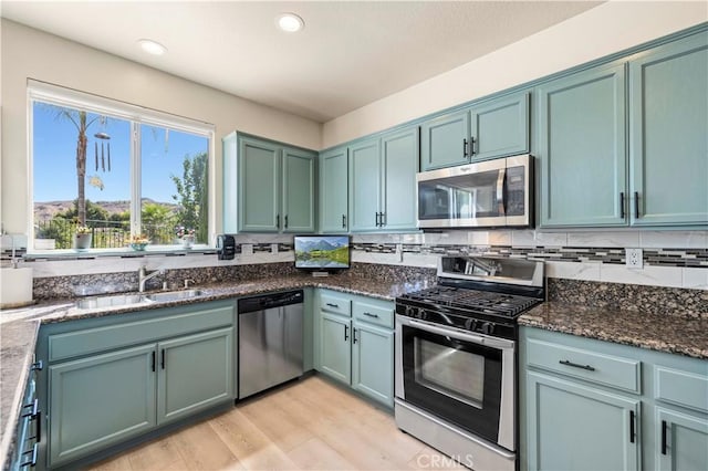 29508 Alyssum Ln, Canyon Country, CA 91387 - kitchen featuring stainless steel appliances, dark stone counters, light wood-style floors, recessed lighting, and decorative backsplash