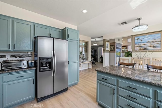 29508 Alyssum Ln, Canyon Country, CA 91387 - kitchen with stainless steel fridge, light wood finished floors, dark stone countertops, pendant lighting, and recessed lighting