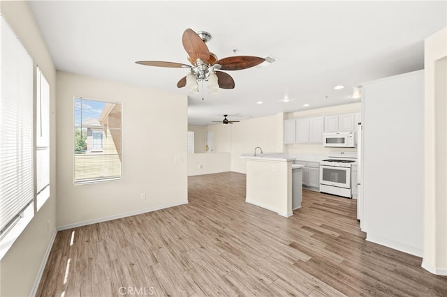 39719 Princeton Way Unit C, Murrieta, CA 92563 - kitchen with white appliances, a ceiling fan, open floor plan, light countertops, and light wood-type flooring