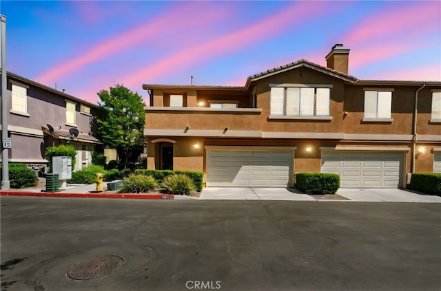 39719 Princeton Way Unit C, Murrieta, CA 92563 - multi unit property featuring stucco siding, a chimney, an attached garage, driveway, and a tiled roof