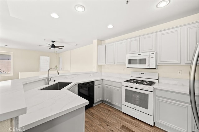 39719 Princeton Way Unit C, Murrieta, CA 92563 - kitchen with white appliances, light stone countertops, a peninsula, ceiling fan, and wood finished floors