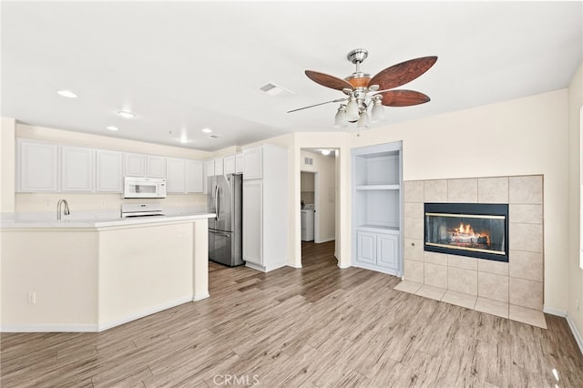 39719 Princeton Way Unit C, Murrieta, CA 92563 - kitchen featuring white microwave, freestanding refrigerator, stove, light wood-style flooring, and recessed lighting