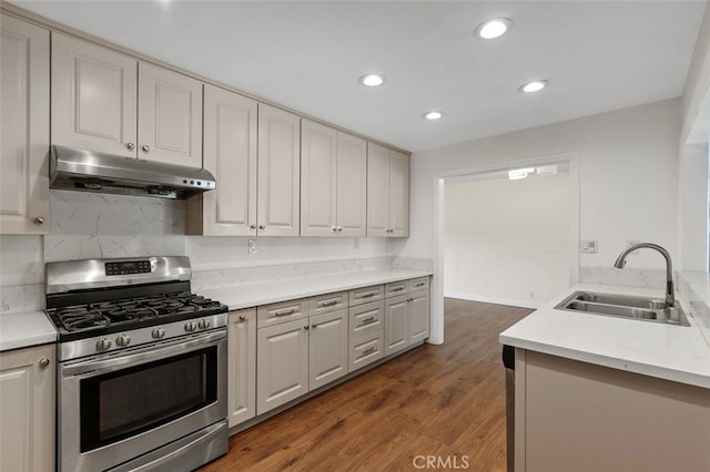 1329 S St Malo St, West Covina, CA 91790 - kitchen with stainless steel range with gas stovetop, under cabinet range hood, recessed lighting, wood finished floors, and tasteful backsplash