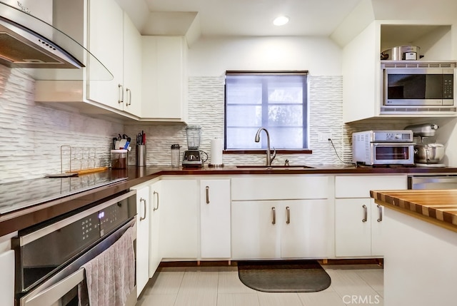 1313 Valley View Rd Unit 103, Glendale, CA 91202 - kitchen with stainless steel microwave, extractor fan, wood counters, wall oven, and decorative backsplash