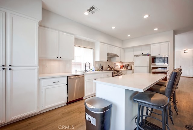 8550 Rolling Hills Dr, Corona, CA 92883 - kitchen featuring appliances with stainless steel finishes, light wood-type flooring, a breakfast bar, a center island, and recessed lighting