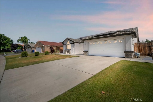 5224 Sierra Caves Ave, Bakersfield, CA 93313 - single story home with stone siding, concrete driveway, solar panels, a garage, and stucco siding