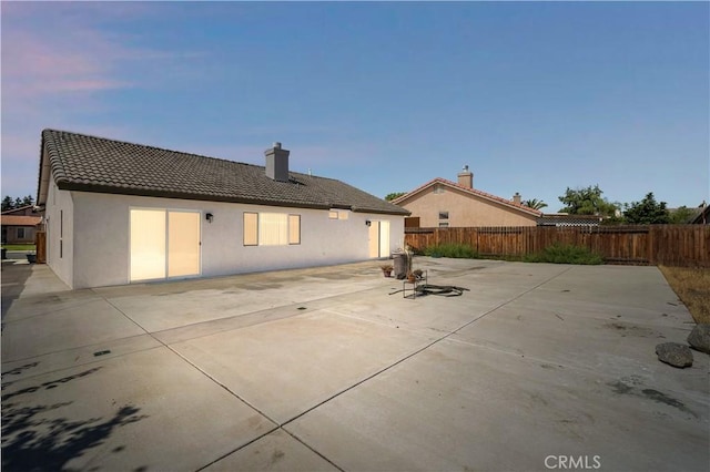5224 Sierra Caves Ave, Bakersfield, CA 93313 - back of property featuring a patio area, stucco siding, a tiled roof, and a chimney