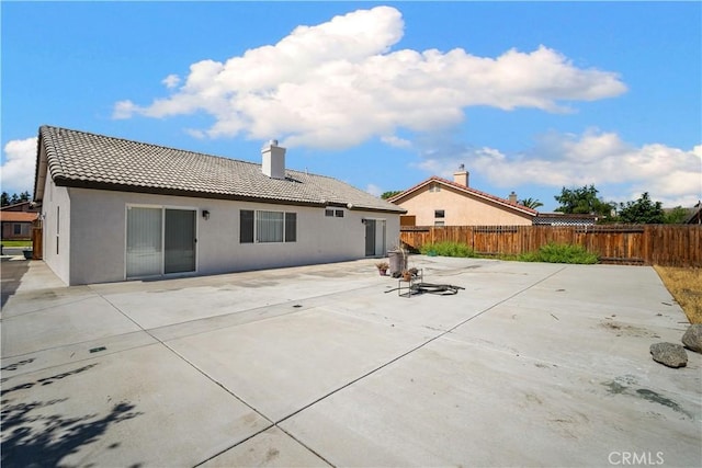 5224 Sierra Caves Ave, Bakersfield, CA 93313 - back of property featuring a tile roof, stucco siding, a patio area, and a chimney