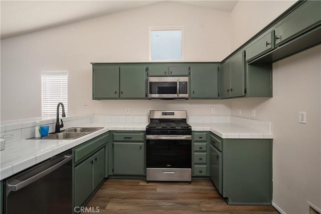 5224 Sierra Caves Ave, Bakersfield, CA 93313 - kitchen featuring appliances with stainless steel finishes, dark wood-type flooring, tile countertops, and lofted ceiling