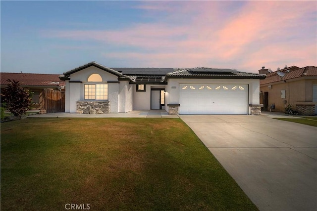 5224 Sierra Caves Ave, Bakersfield, CA 93313 - ranch-style home featuring stone siding, a lawn, roof mounted solar panels, stucco siding, and concrete driveway