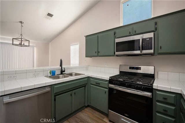 5224 Sierra Caves Ave, Bakersfield, CA 93313 - kitchen with appliances with stainless steel finishes, vaulted ceiling, dark wood-type flooring, tile countertops, and green cabinets
