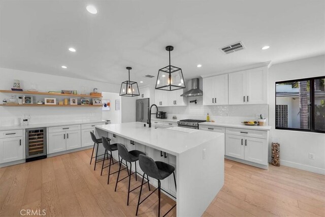 1834 Stearns Dr, Los Angeles, CA 90035 - kitchen with wine cooler, wall chimney range hood, open shelves, high end range, and light countertops