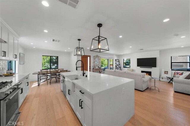 1834 Stearns Dr, Los Angeles, CA 90035 - kitchen featuring high end range, recessed lighting, light wood-style flooring, healthy amount of natural light, and white cabinetry