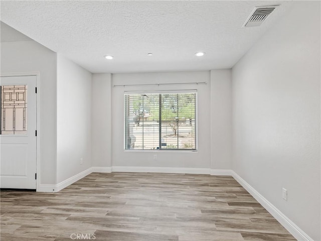 15679 Tuscola Rd, Apple Valley, CA 92307 - empty room with recessed lighting, light wood-type flooring, and a textured ceiling