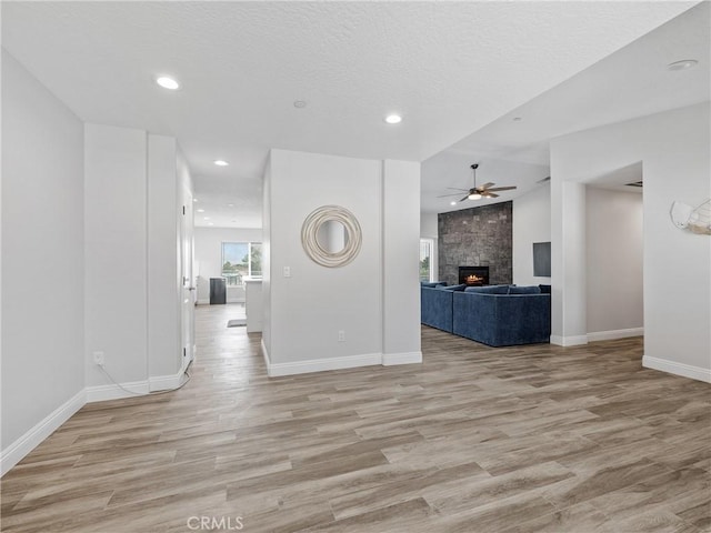 15679 Tuscola Rd, Apple Valley, CA 92307 - unfurnished living room featuring ceiling fan, light wood-type flooring, a large fireplace, and recessed lighting