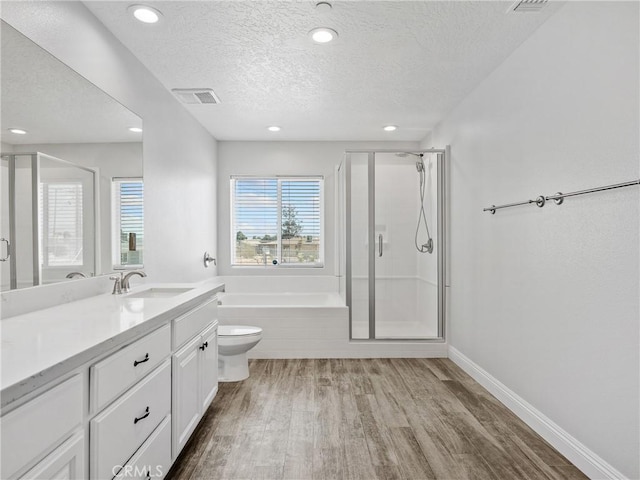15679 Tuscola Rd, Apple Valley, CA 92307 - bathroom featuring a textured ceiling, a shower stall, a bath, wood finished floors, and vanity
