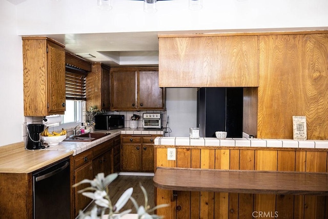 27820 Ferguson Dr, Castaic, CA 91384 - kitchen with dishwasher, stainless steel microwave, tile countertops, dark wood finished floors, and brown cabinetry