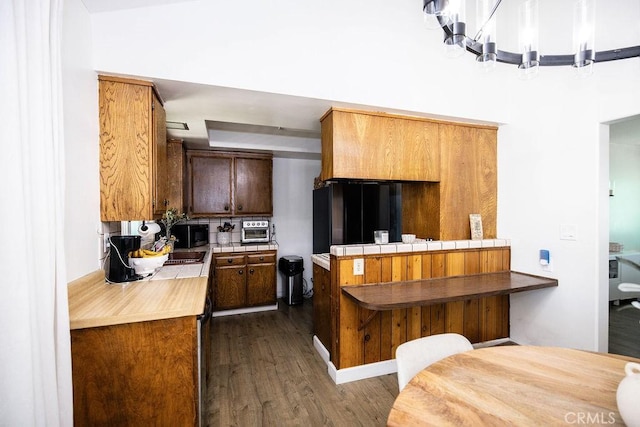 27820 Ferguson Dr, Castaic, CA 91384 - kitchen with stainless steel microwave, dark wood-type flooring, a chandelier, and tile countertops