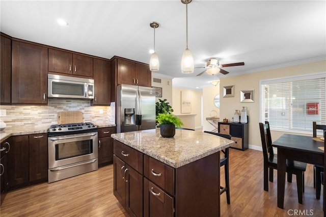 16660 Spruce Cir, Fountain Valley, CA 92708 - kitchen with appliances with stainless steel finishes, backsplash, ceiling fan, dark brown cabinetry, and ornamental molding