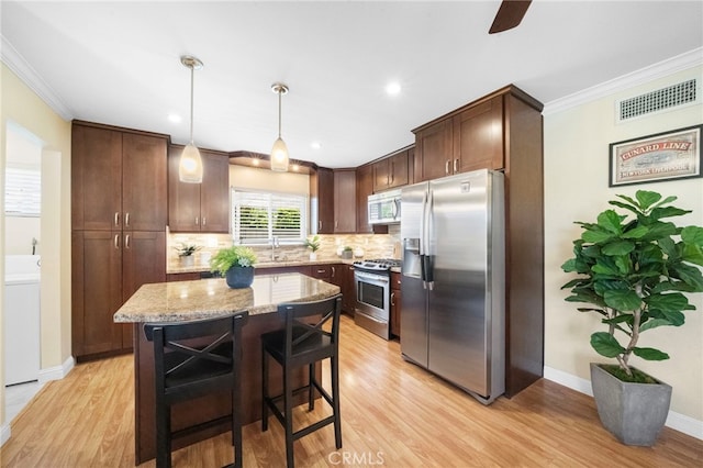 16660 Spruce Cir, Fountain Valley, CA 92708 - kitchen with appliances with stainless steel finishes, tasteful backsplash, light wood finished floors, light stone counters, and crown molding