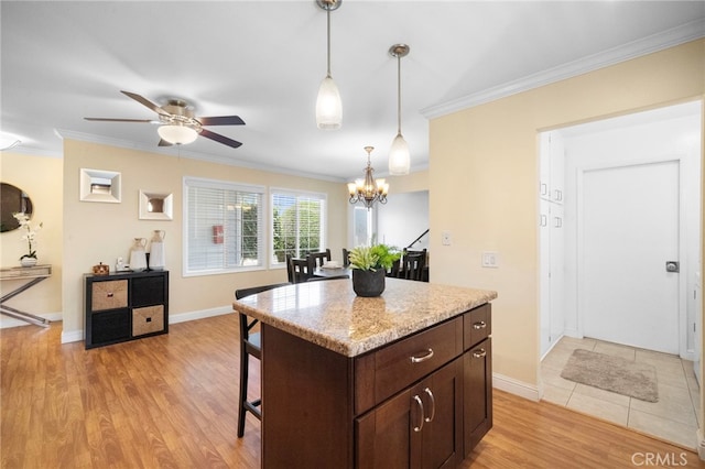 16660 Spruce Cir, Fountain Valley, CA 92708 - kitchen featuring a breakfast bar area, ornamental molding, dark brown cabinetry, pendant lighting, and light wood finished floors