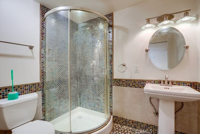 20606 Skouras Dr, Winnetka, CA 91306 - bathroom with tile walls, a stall shower, and a wainscoted wall