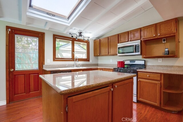 20606 Skouras Dr, Winnetka, CA 91306 - kitchen featuring stainless steel appliances, open shelves, lofted ceiling, a skylight, and healthy amount of natural light