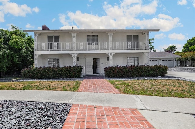 1411 Woodcrest Ave, La Habra, CA 90631 - view of front of property featuring a balcony, stucco siding, a garage, and a chimney