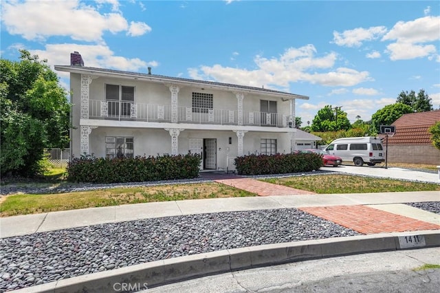 1411 Woodcrest Ave, La Habra, CA 90631 - view of front of house with a balcony, stucco siding, and a chimney