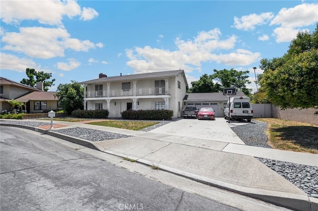 1411 Woodcrest Ave, La Habra, CA 90631 - view of front of property with driveway, a balcony, an attached garage, stucco siding, and a chimney