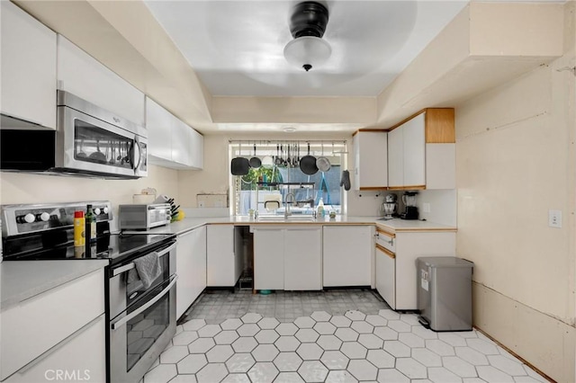 1411 Woodcrest Ave, La Habra, CA 90631 - kitchen featuring stainless steel appliances, light countertops, white cabinetry, a tray ceiling, and light tile patterned floors