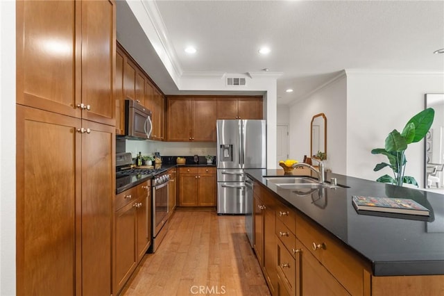 13028 Central Ave Unit 202, Hawthorne, CA 90250 - kitchen with stainless steel appliances, dark countertops, crown molding, light wood-style flooring, and brown cabinets