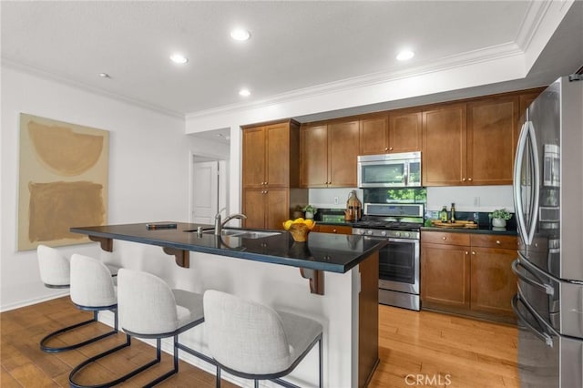 13028 Central Ave Unit 202, Hawthorne, CA 90250 - kitchen with appliances with stainless steel finishes, light wood finished floors, crown molding, dark countertops, and a breakfast bar