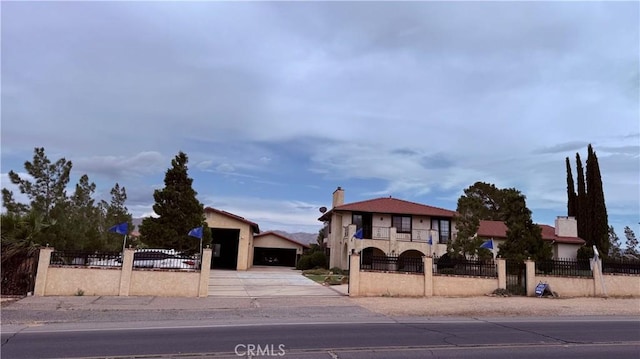 9535 Timberlane Ave, Hesperia, CA 92345 - view of front of house featuring driveway, a fenced front yard, a chimney, a balcony, and stucco siding