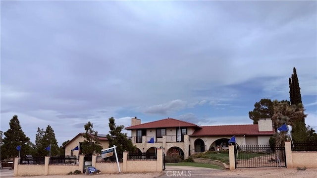 9535 Timberlane Ave, Hesperia, CA 92345 - mediterranean / spanish home featuring stucco siding, a chimney, a fenced front yard, and a balcony