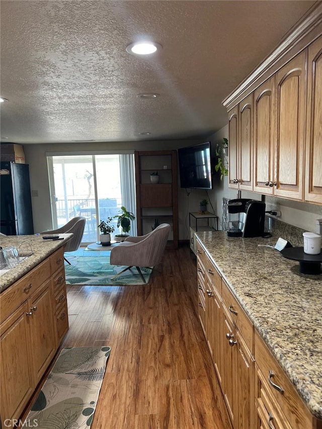 9535 Timberlane Ave, Hesperia, CA 92345 - kitchen with dark wood-style floors, a textured ceiling, light stone countertops, brown cabinetry, and recessed lighting