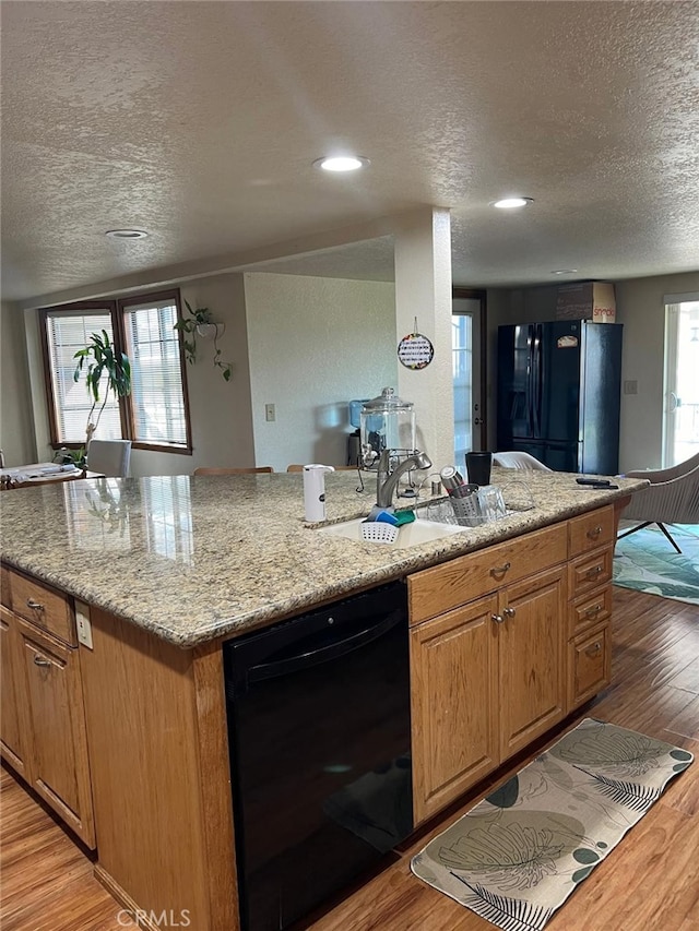 9535 Timberlane Ave, Hesperia, CA 92345 - kitchen with a textured ceiling, light wood finished floors, black appliances, light stone counters, and recessed lighting