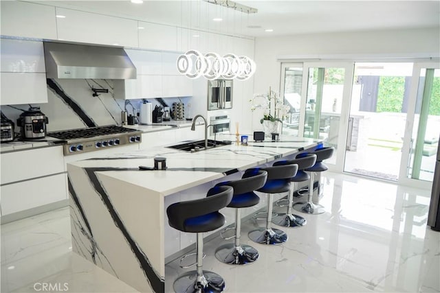 9359 Cecilia St, Downey, CA 90241 - kitchen with wall chimney range hood, modern cabinets, light marble finish flooring, white cabinetry, and recessed lighting