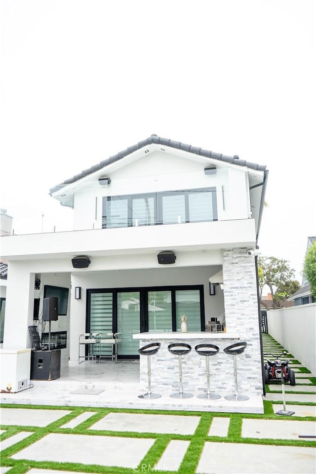 9359 Cecilia St, Downey, CA 90241 - back of house with a balcony, a patio area, stucco siding, and stone siding