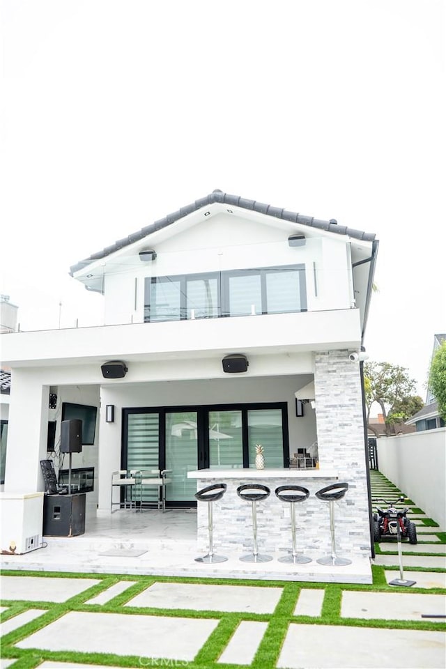 9359 Cecilia St, Downey, CA 90241 - rear view of property with a balcony, a patio area, stucco siding, and stone siding