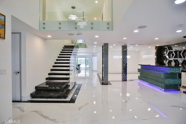 9359 Cecilia St, Downey, CA 90241 - staircase featuring marble tiled floors, a high ceiling, and recessed lighting