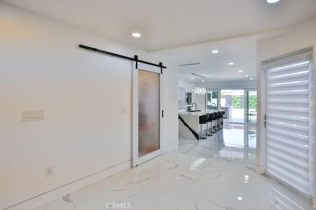 9359 Cecilia St, Downey, CA 90241 - hallway featuring light marble finish flooring, recessed lighting, and a barn door