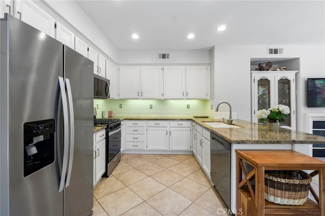 3 Kyle Ct, Ladera Ranch, CA 92694 - kitchen featuring appliances with stainless steel finishes, a peninsula, light stone counters, white cabinets, and tasteful backsplash