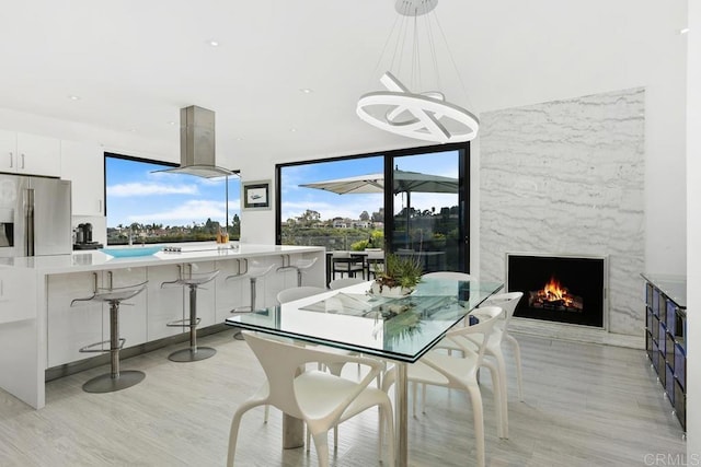 6544 Caminito Northland Ln, Jolla, CA 92037 - dining area featuring light wood finished floors, a chandelier, a high end fireplace, and recessed lighting