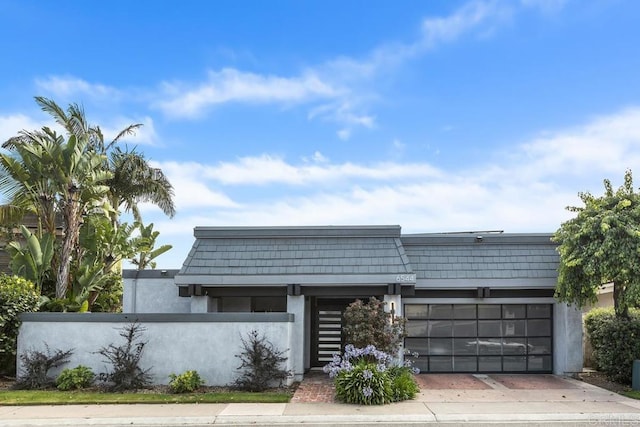 6544 Caminito Northland Ln, Jolla, CA 92037 - view of front of home with a fenced front yard, mansard roof, stucco siding, and a garage