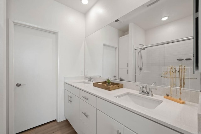 5252 Beachfront Cove St Unit 197, San Diego, CA 92154 - bathroom featuring double vanity, a tile shower, and wood finished floors