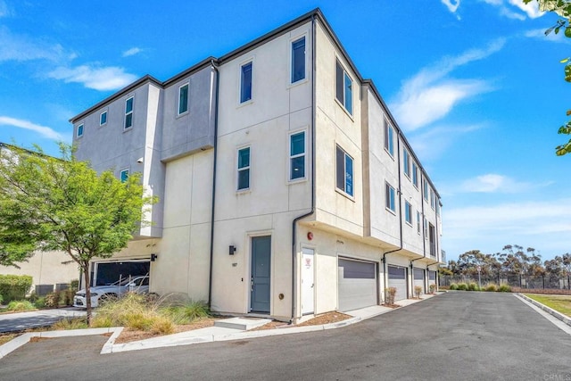 5252 Beachfront Cove St Unit 197, San Diego, CA 92154 - view of building exterior featuring a garage and driveway
