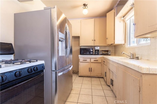6644 Bothwell Rd, Reseda, CA 91335 - kitchen featuring gas stove, decorative backsplash, light tile patterned floors, black microwave, and tile countertops