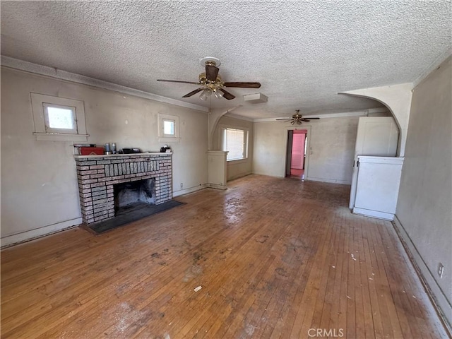29095 Arrowhead Ave, Barstow, CA 92311 - unfurnished living room featuring wood-type flooring, a ceiling fan, a fireplace, a textured ceiling, and washer / dryer