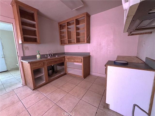 29095 Arrowhead Ave, Barstow, CA 92311 - kitchen with open shelves, light tile patterned flooring, and dark countertops
